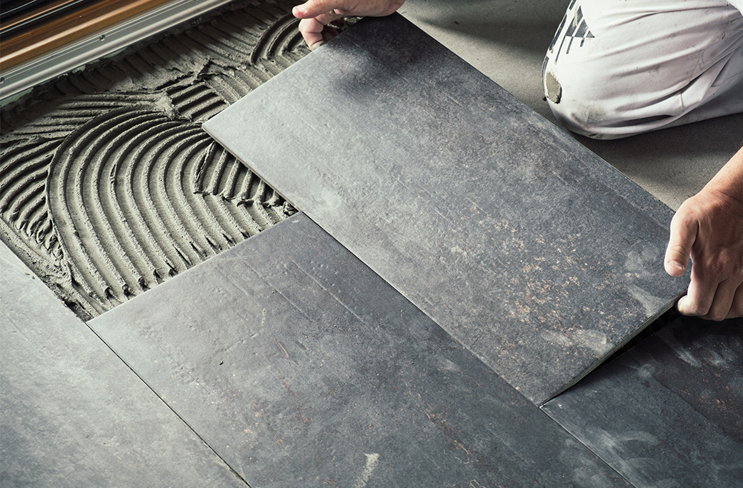 Ceramic bathroom floor tile being installed during a Rhode Island renovation